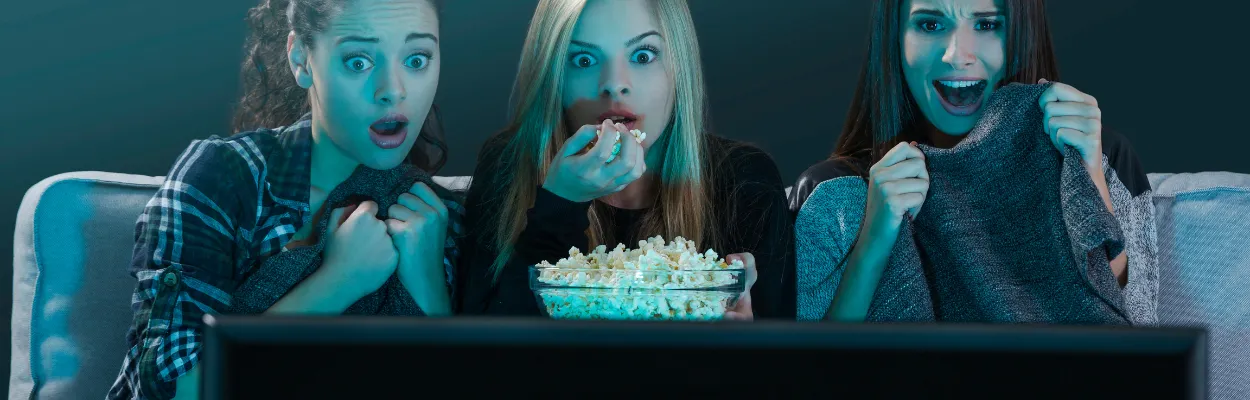 Trzy koleżanki oglądające serial i jedzące popcorn